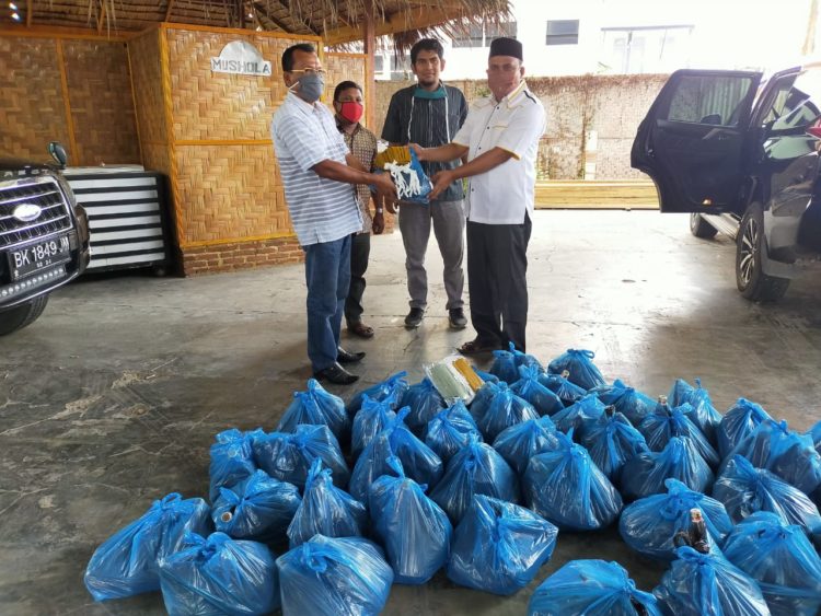 Wakil Ketua DPRK Aceh Besar, Zulfikar Aziz, SE (kanan) menyerahkan paket ramadhan untuk Perwabes, Kamis, 23 April 2020