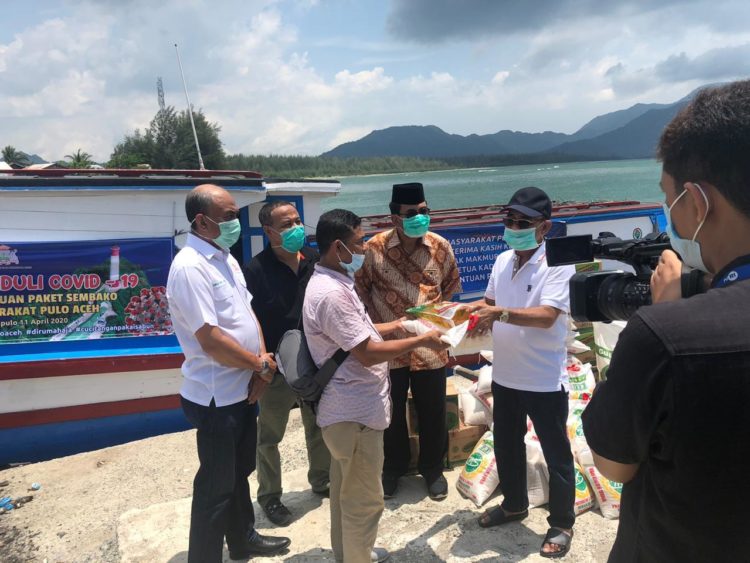 Ketua Kadin Aceh, H. Makmur Budiman, SE (baju batik merah) menyaksikan penyerahan paket sembako dari Kadin Aceh secara simbolis pada perwakilan warga Pulau Aceh, Sabtu, 11 April 2020