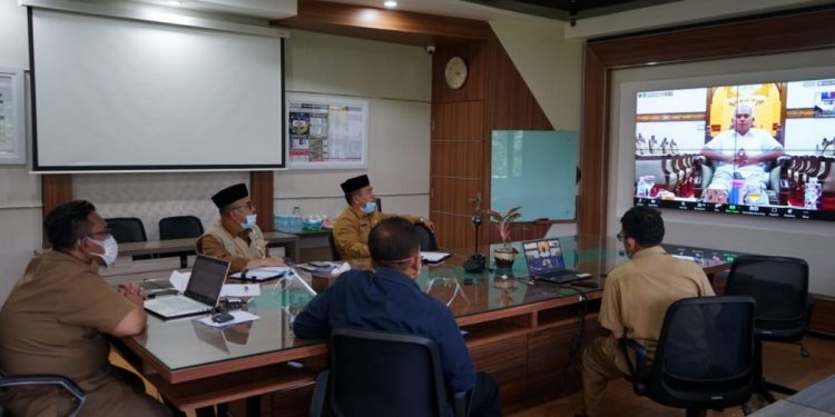 Sekda Aceh dr. Taqwallah, M.Kes melakukan vidcon mingguan dengan tema “menghadapi peningkatan Covid 19 di Indonesia pasca libur panjang dan pengaruhnya terhadap Aceh serta Sosialisasi GESID bersama Satgas Covid-19 di Ruang Rapat Sekda, Banda Aceh, Selasa (8/12/2020).
